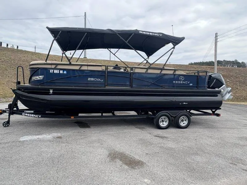 Slide: The Image of 2020 Regency 250 DL3 pontoon boat on trailer, parked outdoors. - 25