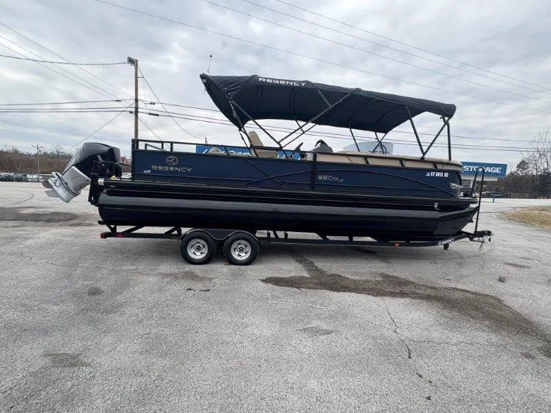Slide: The Image of 2020 Regency 250 DL3 pontoon boat on trailer, parked outdoors under cloudy sky. - 27