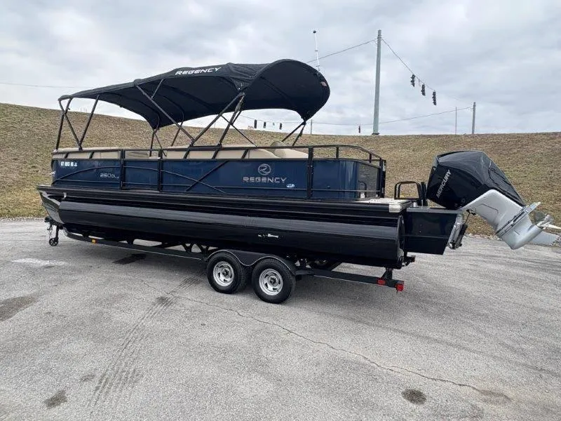 Slide: The Image of 2020 Regency 250 DL3 pontoon boat on trailer, parked outdoors. - 29