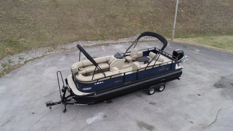Slide: The Image of 2020 Regency 250 DL3 pontoon boat on trailer, parked on paved surface. - 3
