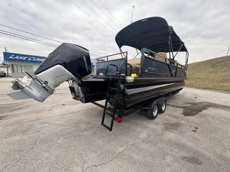 Slide: The Image of 2020 Regency 250 DL3 pontoon boat with Mercury outboard motor, parked on a trailer. - 31