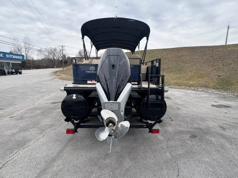 Slide: The Image of 2020 Regency 250 DL3 pontoon boat with outboard motor, parked on paved surface. - 35