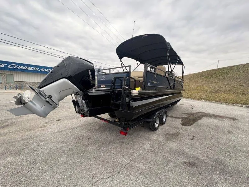 Slide: The Image of 2020 Regency 250 DL3 pontoon boat on trailer, featuring a black canopy and powerful outboard motor. - 37
