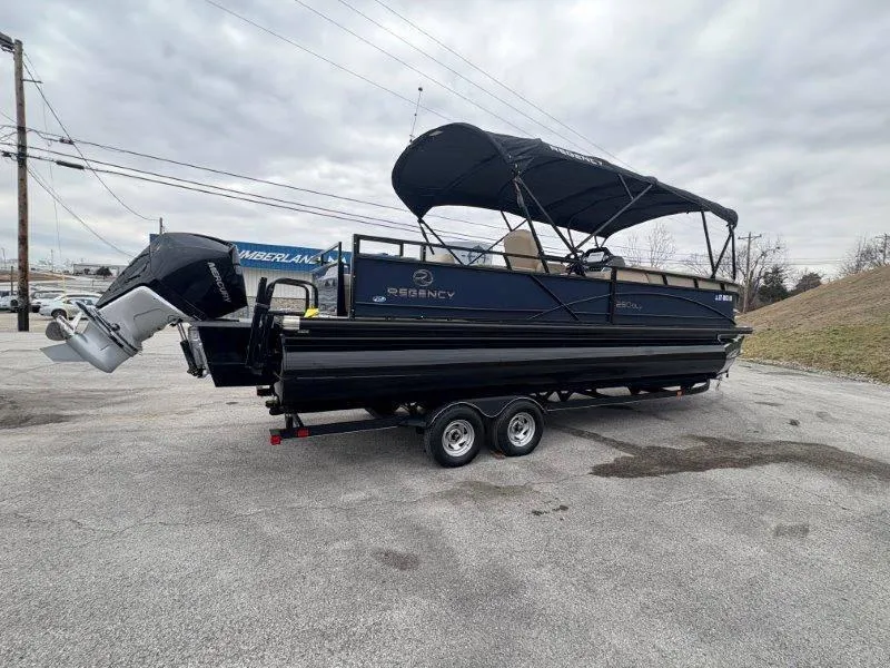 Slide: The Image of 2020 Regency 250 DL3 pontoon boat on trailer, parked outdoors under cloudy sky. - 39