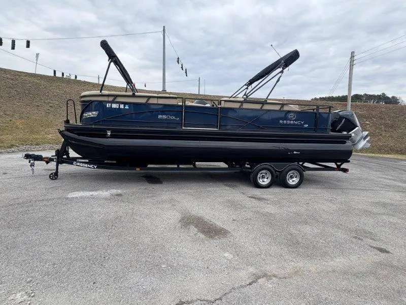 Slide: The Image of 2020 Regency 250 DL3 pontoon boat on trailer, parked outdoors. - 46