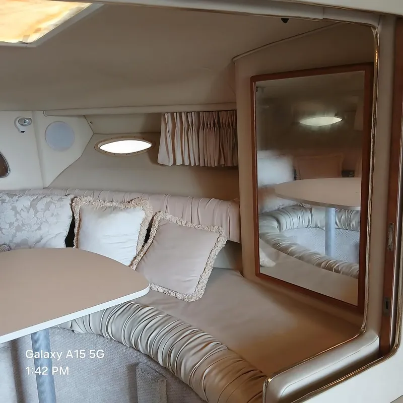 Slide: The Image of Interior of 2000 Sea Ray Amberjack 340, featuring cozy seating and a mirror. - 8