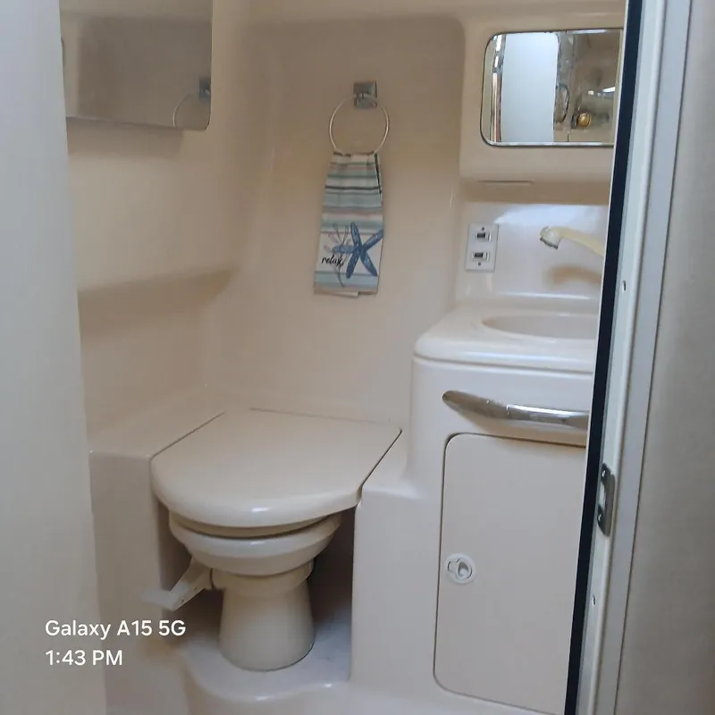 Slide: The Image of Compact bathroom in a 2000 Sea Ray Amberjack 340 boat, featuring a toilet and sink. - 9