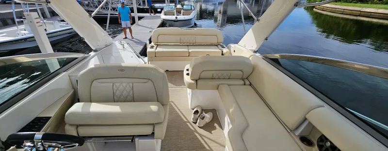Slide: The Image of 2018 Regal 33 XO boat interior with beige seating at a marina. - 20