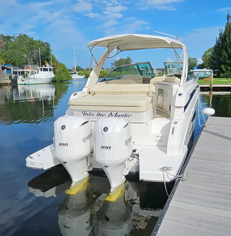 Slide: The Image of 2018 Regal 33 XO boat docked with twin 300 HP engines, sunny day. - 23