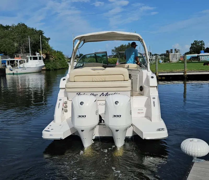 Slide: The Image of 2018 Regal 33 XO boat with dual engines on a calm waterway. - 24