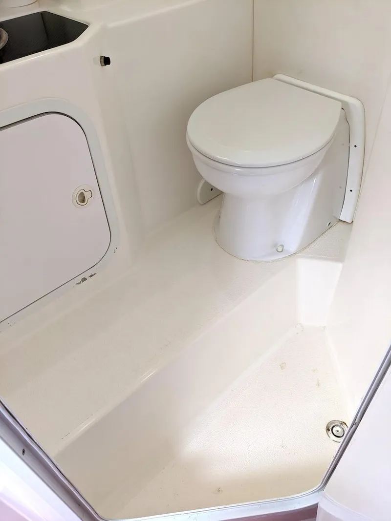 Slide: The Image of 2001 Nor-Tech 500 boat interior bathroom with white toilet and storage compartment. - 6