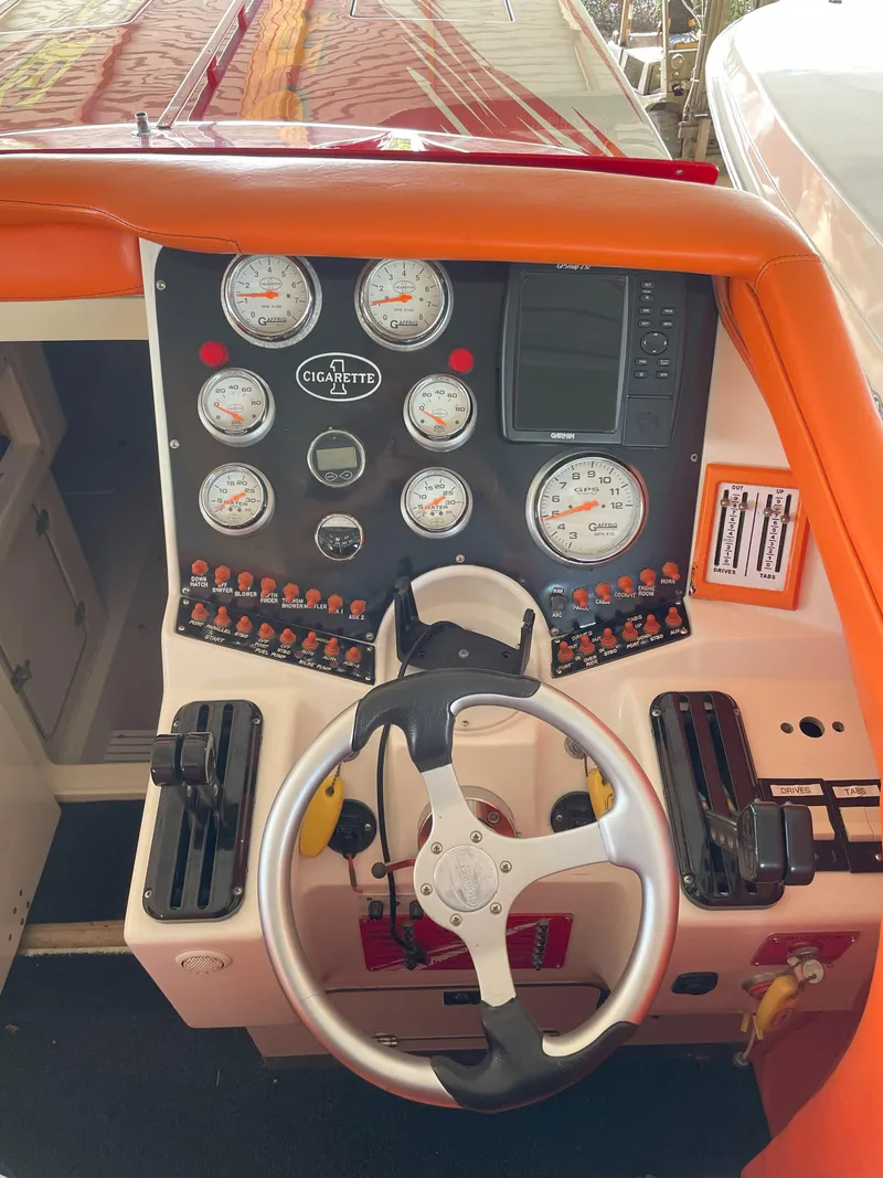 Slide: The Image of Dashboard of a 2002 Cigarette ROUGH RIDER boat with gauges and steering wheel. - 11
