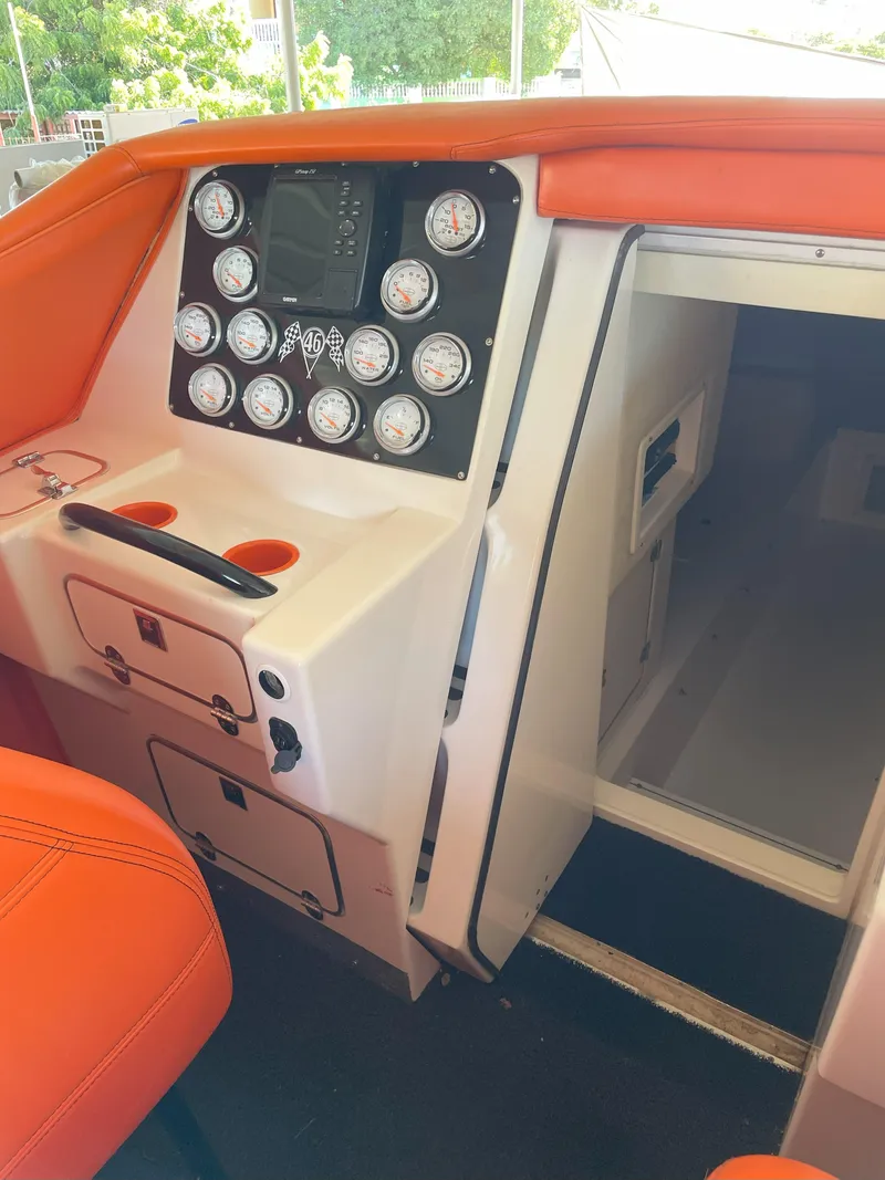 Slide: The Image of 2002 Cigarette ROUGH RIDER boat interior with orange seating and control panel. - 12