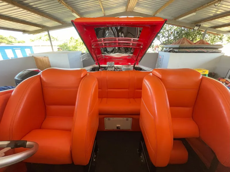 Slide: The Image of 2002 Cigarette ROUGH RIDER boat interior with vibrant orange seating and open engine compartment. - 13