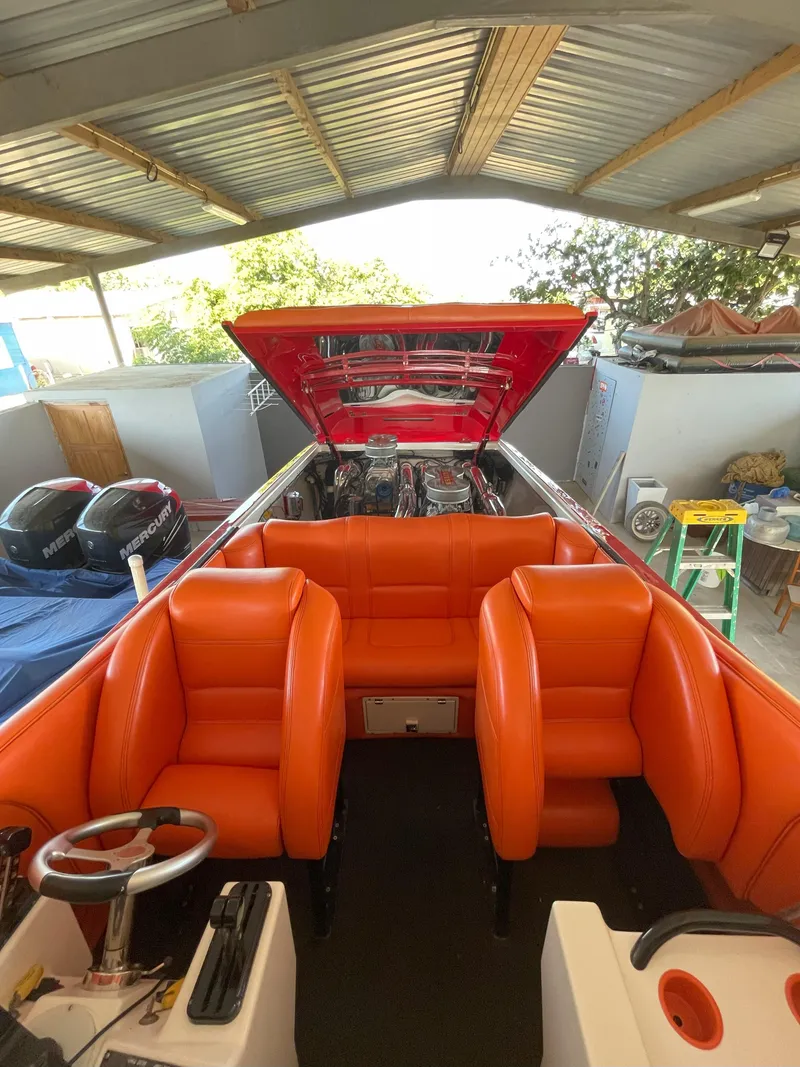 Slide: The Image of 2002 Cigarette ROUGH RIDER boat with vibrant orange seating under a metal roof. - 15