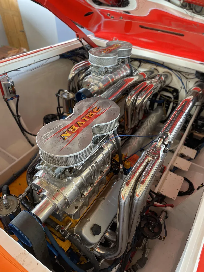 Slide: The Image of Engine of a 2002 Cigarette ROUGH RIDER boat with chrome components and dual carburetors. - 16