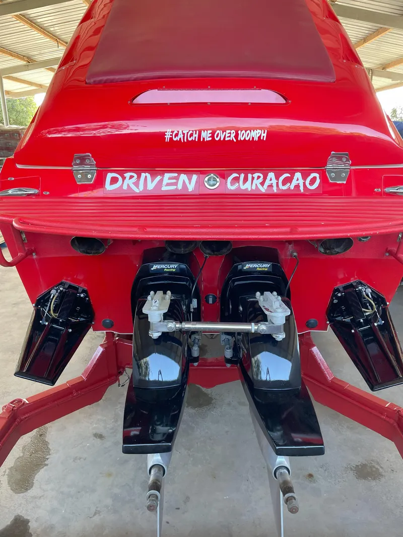 Slide: The Image of Red Cigarette ROUGH RIDER 2002 boat with dual engines, "Driven Curacao" text. - 21