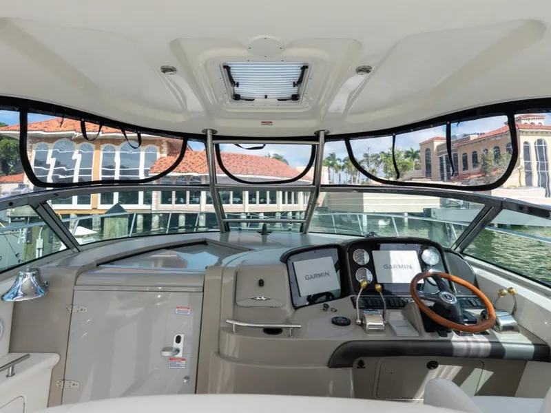 Slide: The Image of 2005 Sea Ray 390 Sundancer helm with Garmin navigation, docked near waterfront buildings. - 15
