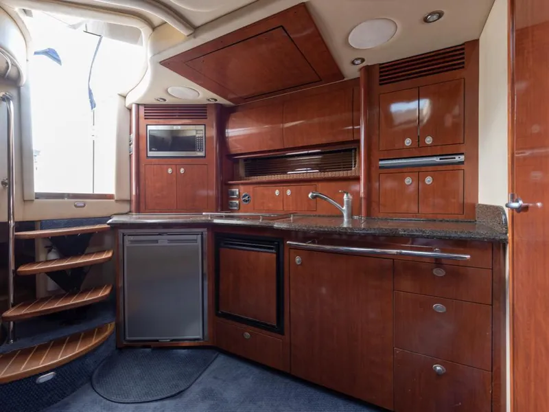 Slide: The Image of Interior of 2005 Sea Ray 390 Sundancer yacht kitchen with wood cabinetry and modern appliances. - 22