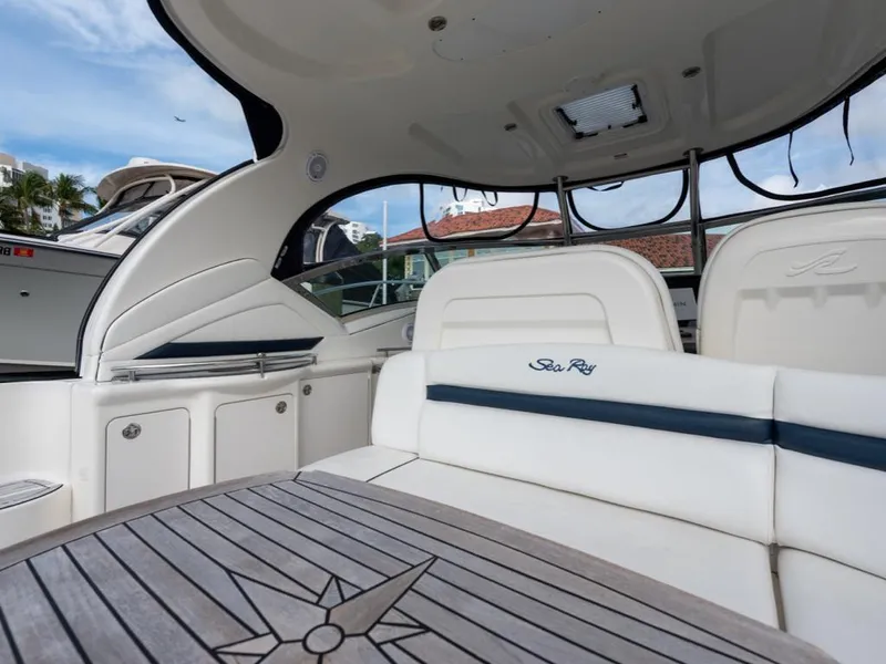 Slide: The Image of Interior of 2005 Sea Ray 390 Sundancer yacht with white seating and wooden table. - 8