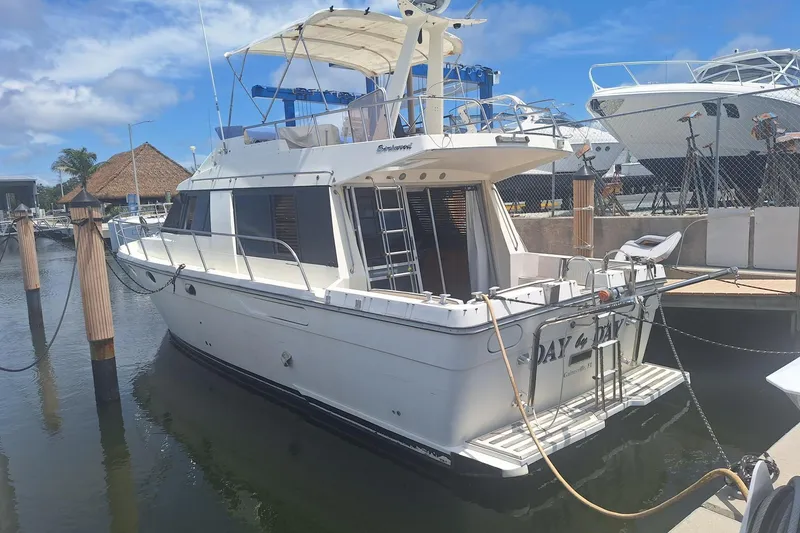 The Image of 1988 Birchwood 44TS yacht docked at marina under clear blue sky. - 0