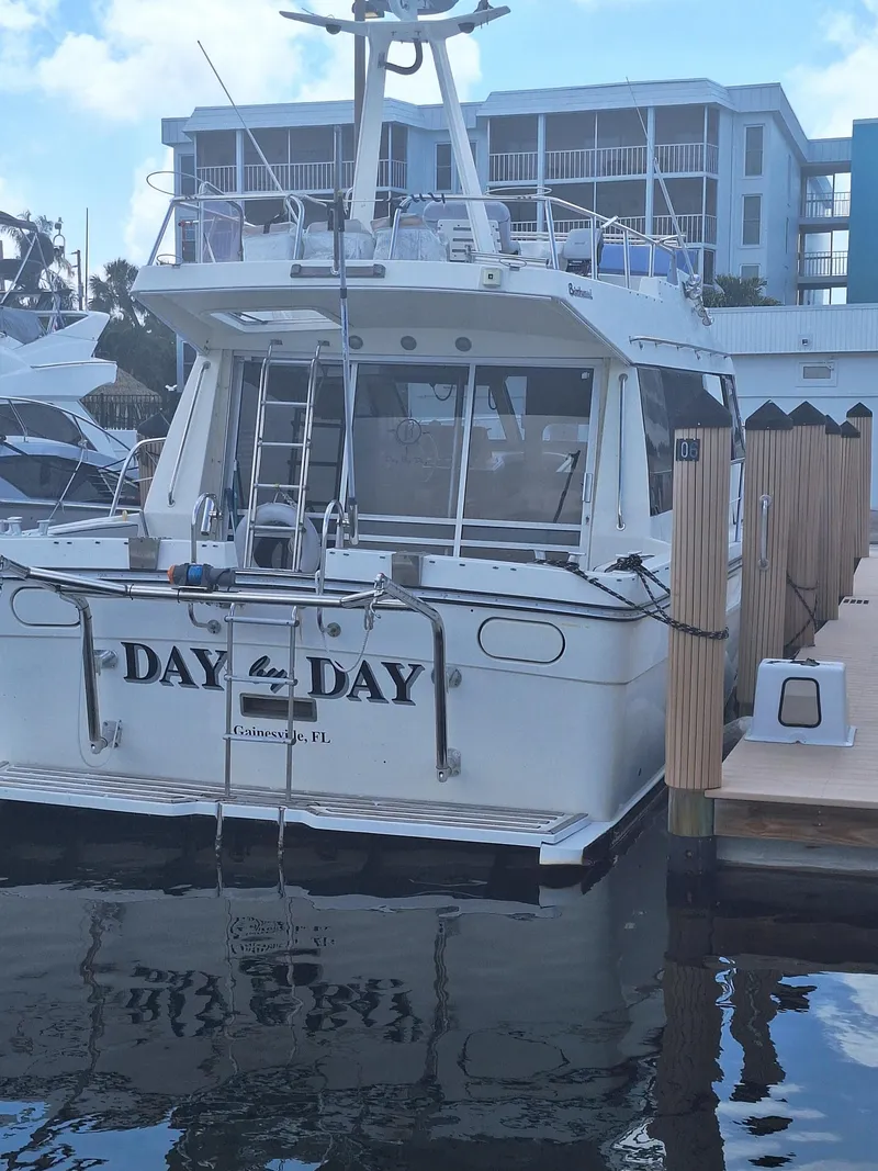 Slide: The Image of 1988 Birchwood 44TS boat docked at marina, named "Day by Day." - 47