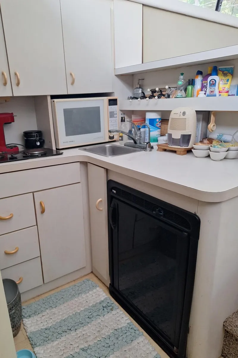 Slide: The Image of Compact kitchen in a 1992 Silverton 34 Convertible boat with appliances and storage. - 13