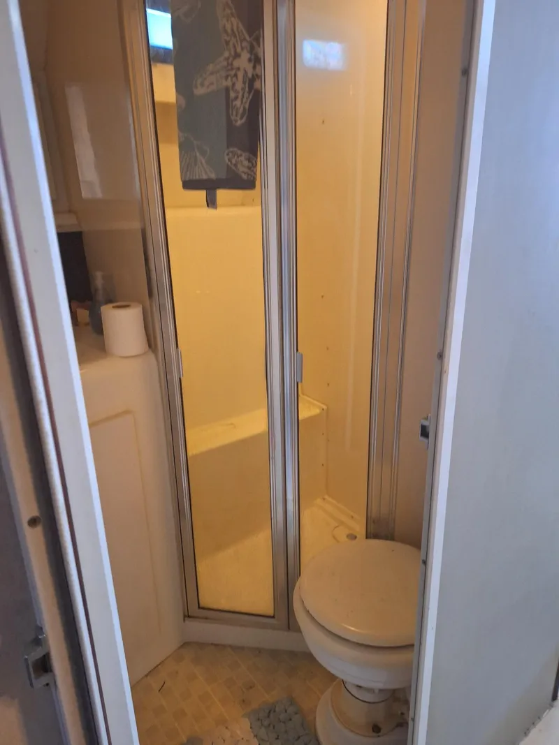 Slide: The Image of 1992 Silverton 34 Convertible boat bathroom with shower and toilet. - 16