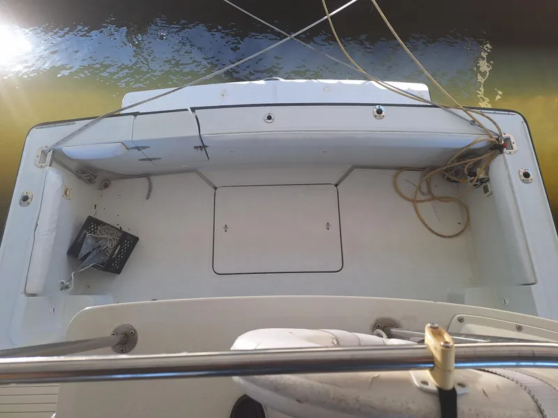 Slide: The Image of 1992 Silverton 34 Convertible boat deck with storage and ropes, docked by the water. - 3