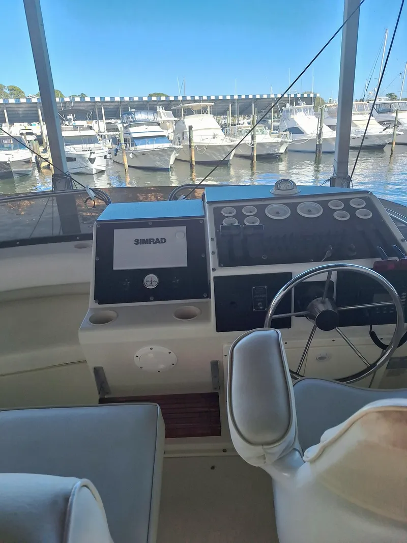 Slide: The Image of 1992 Silverton 34 Convertible boat helm with marina view in the background. - 4