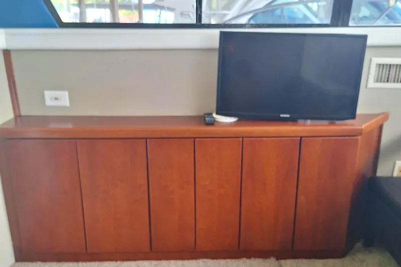 Slide: The Image of 1992 Silverton 34 Convertible interior with wooden cabinet and flat-screen TV. - 6