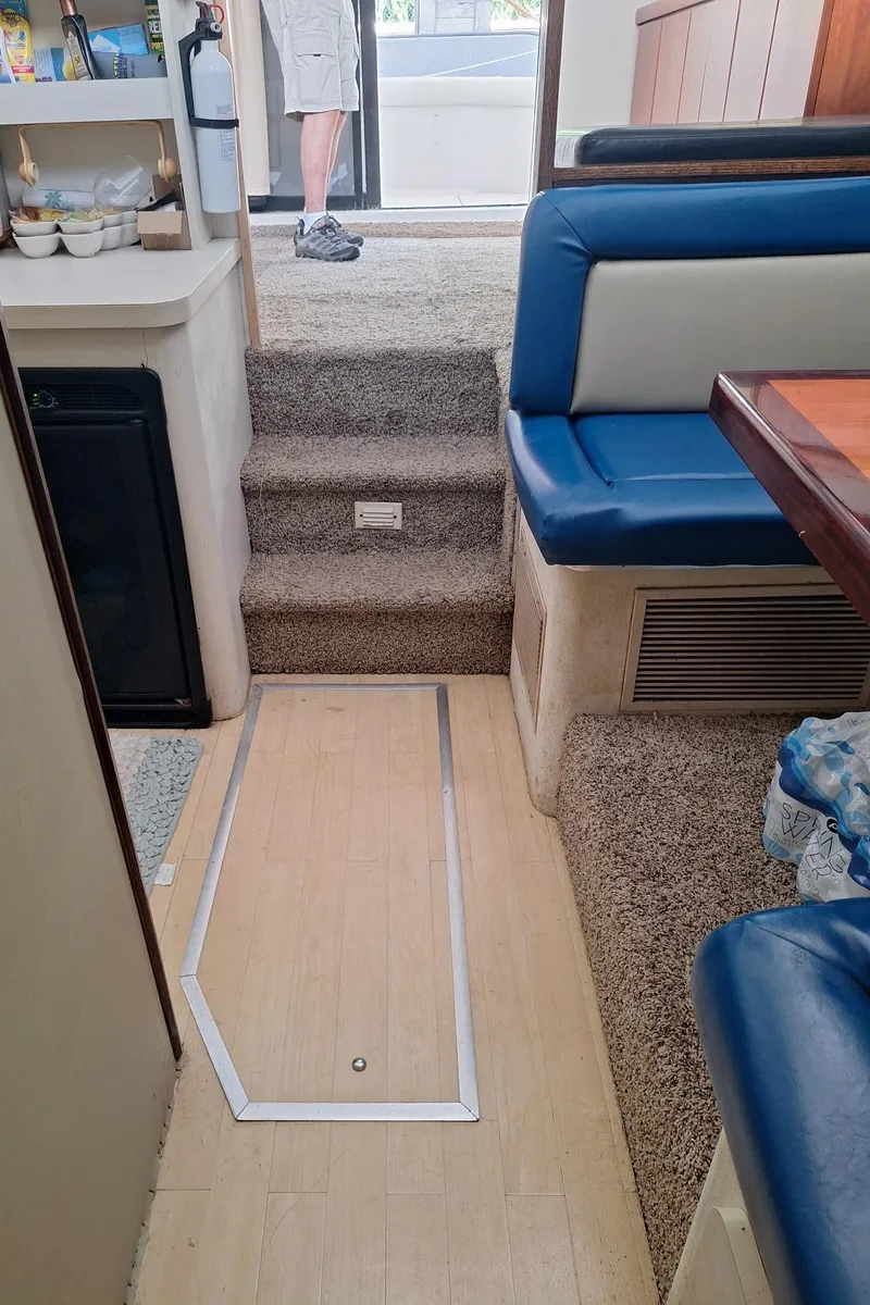 Slide: The Image of Interior of a 1992 Silverton 34 Convertible boat with blue seating and carpeted steps. - 9