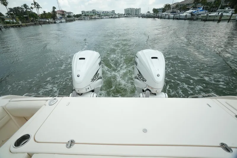 Slide: The Image of 2019 Grady-White Canyon 336 boat with dual outboard engines on a waterway. - 13