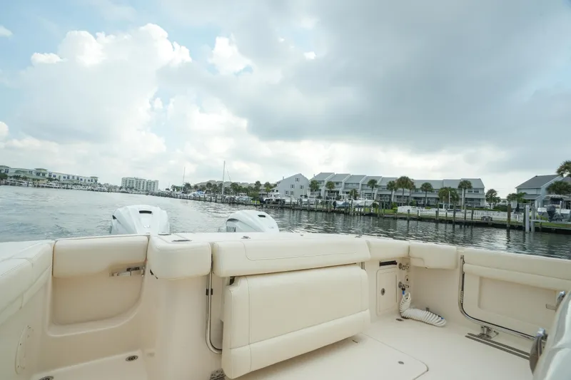 Slide: The Image of 2019 Grady-White Canyon 336 boat on calm waters near waterfront homes. - 15