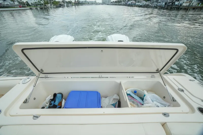 Slide: The Image of 2019 Grady-White Canyon 336 boat storage compartment with open lid, showing various items inside. - 17