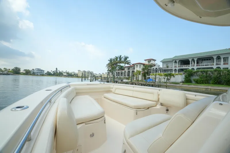 Slide: The Image of 2019 Grady-White Canyon 336 boat with luxurious seating, cruising near waterfront homes. - 23