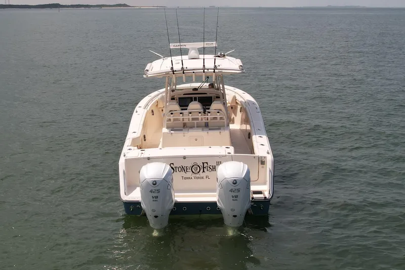 Slide: The Image of 2019 Grady-White Canyon 336 boat on calm water, rear view with dual engines. - 8