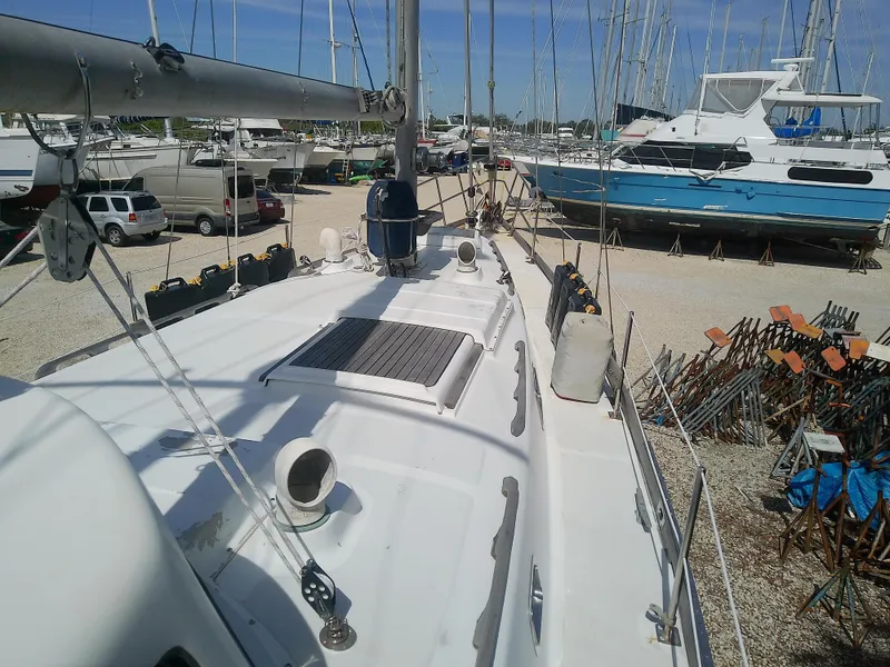Slide: The Image of 1971 Morgan 40 Cruising Ketch sailboat on land, surrounded by other boats and equipment. - 13