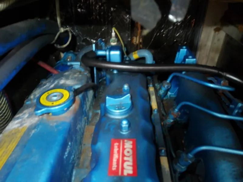 Slide: The Image of Engine compartment of a 1971 Morgan 40 Cruising Ketch, featuring blue components and Motul branding. - 34