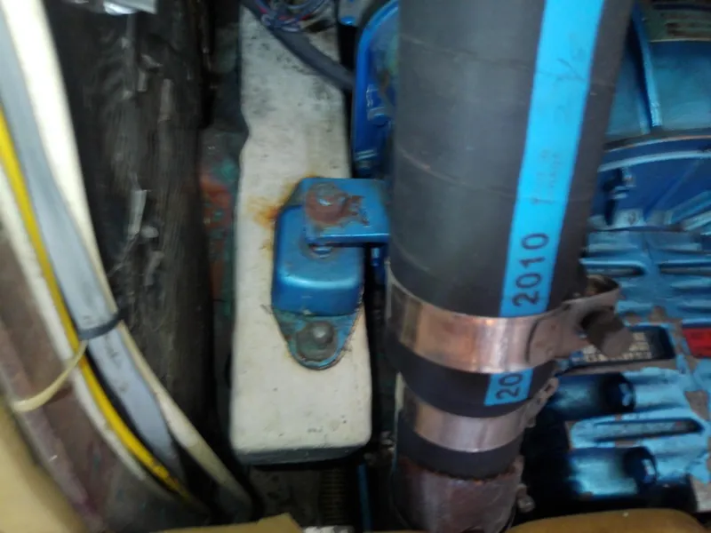 Slide: The Image of Engine compartment of a 1971 Morgan 40 Cruising Ketch, showing hoses and metal components. - 36