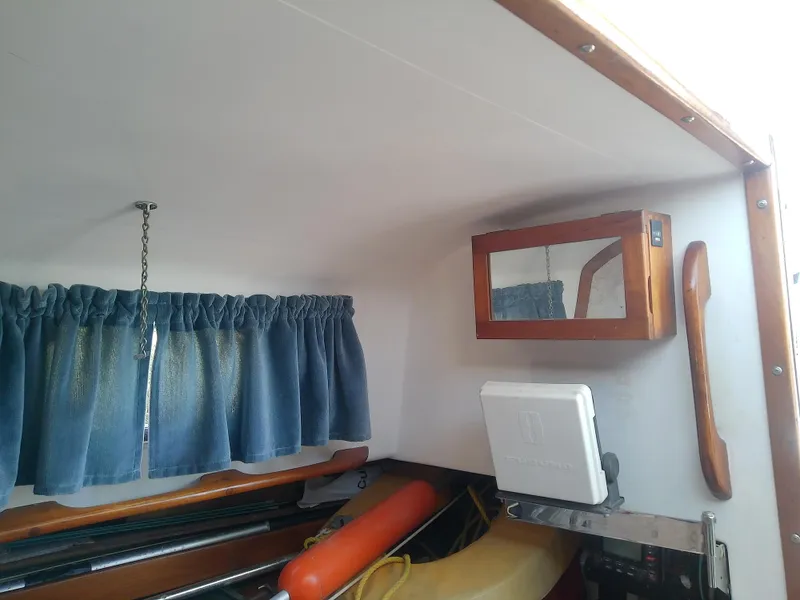 Slide: The Image of Interior of 1971 Morgan 40 Cruising Ketch with blue curtains and wooden cabinetry. - 43