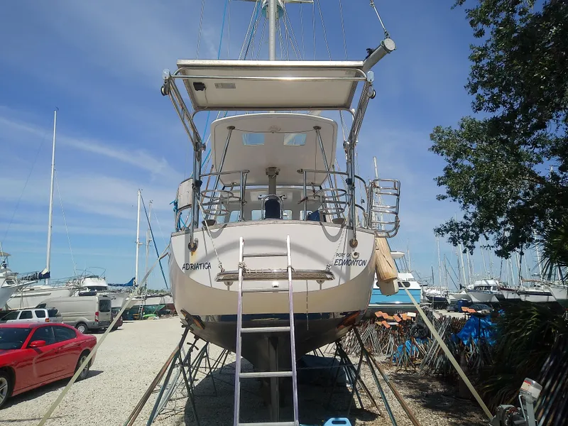 Slide: The Image of 1971 Morgan 40 Cruising Ketch on land, ladder access, surrounded by boats and trees. - 8