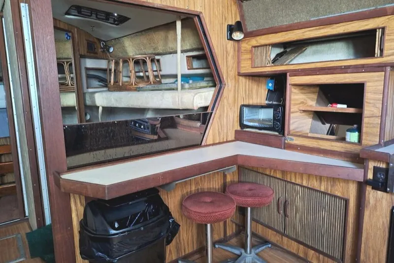 Slide: The Image of 1985 Sea Ray 390 Express Cruiser interior with kitchenette and seating area. - 13