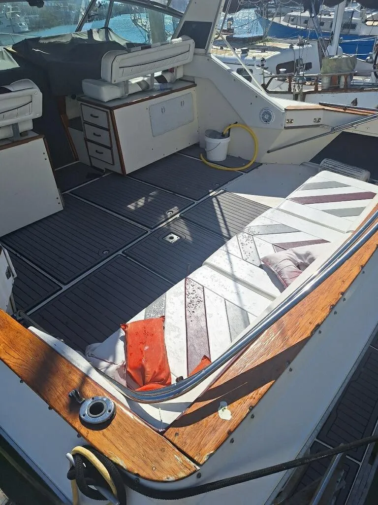 Slide: The Image of 1985 Sea Ray 390 Express Cruiser interior with seating and storage, docked at marina. - 2