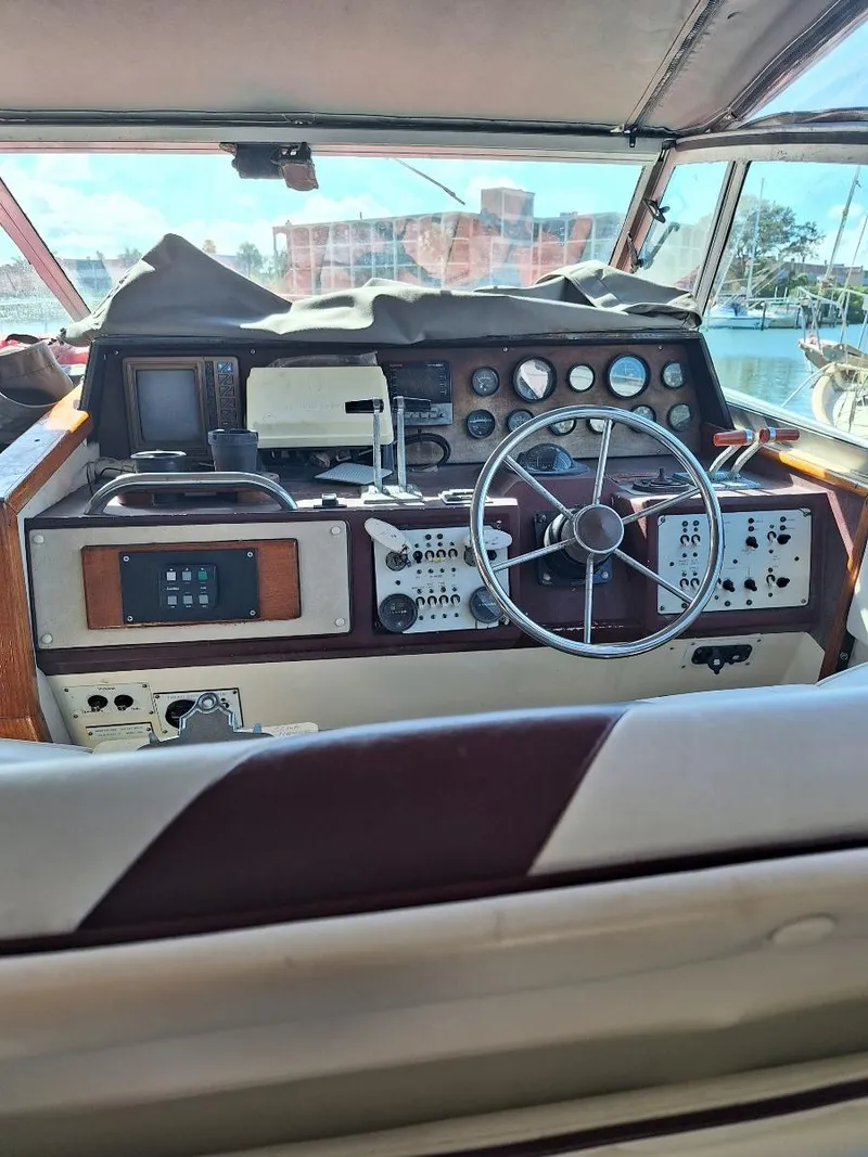 Slide: The Image of 1985 Sea Ray 390 Express Cruiser helm with steering wheel and control panels. - 9
