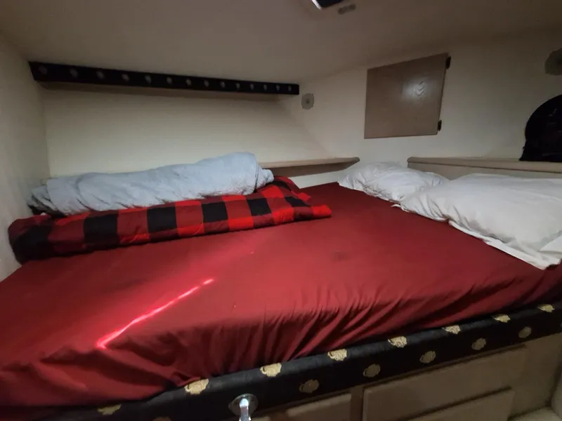 Slide: The Image of Cozy cabin bed in 1996 Hatteras 42 Cockpit MY with red bedding and pillows. - 13