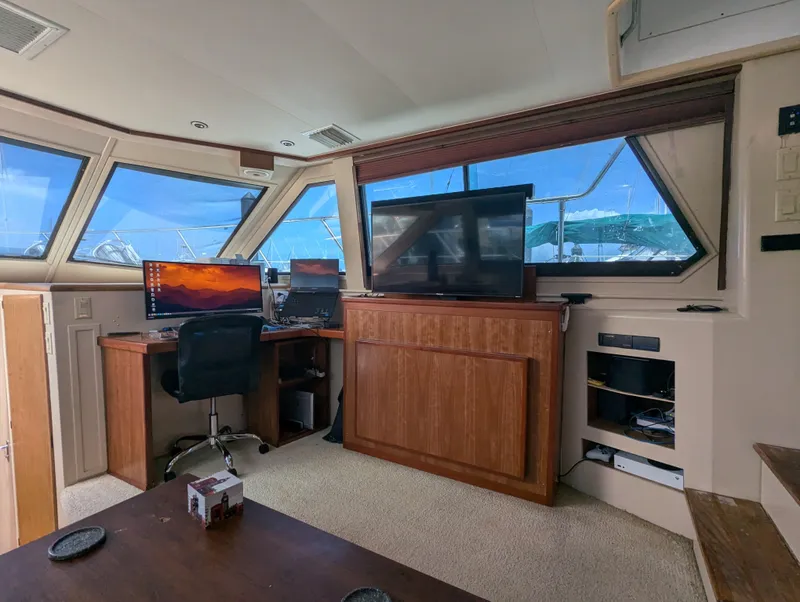 Slide: The Image of Interior of 1996 Hatteras 42 Cockpit MY yacht with office setup and large windows. - 16