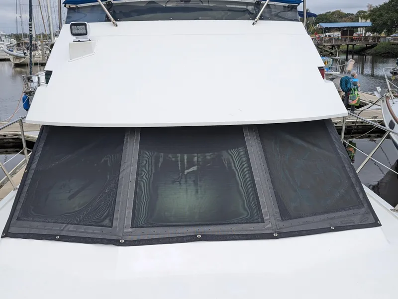 Slide: The Image of 1996 Hatteras 42 Cockpit MY yacht with covered windows at a marina. - 2