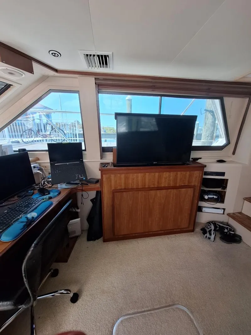 Slide: The Image of Interior of 1996 Hatteras 42 Cockpit MY with office setup and large windows. - 20