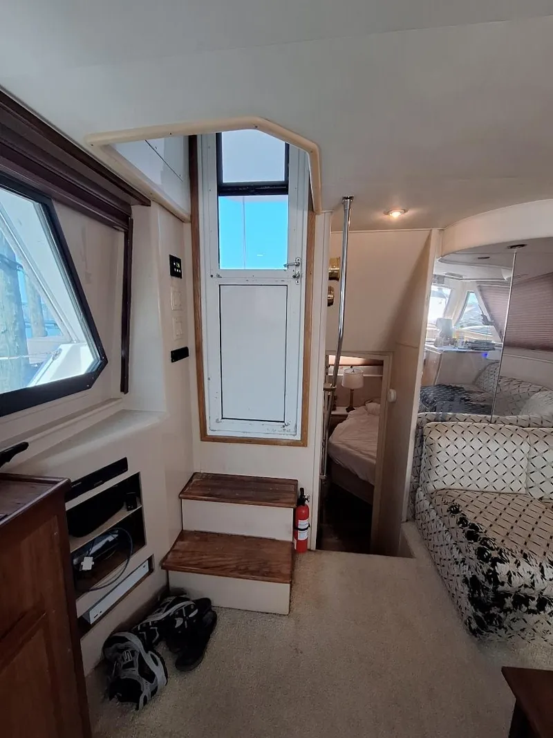 Slide: The Image of Interior of 1996 Hatteras 42 Cockpit MY yacht, featuring stairs and cozy cabin space. - 25